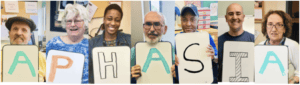 A linear progression of people holding colored letters that spell out the word "APHASIA".
